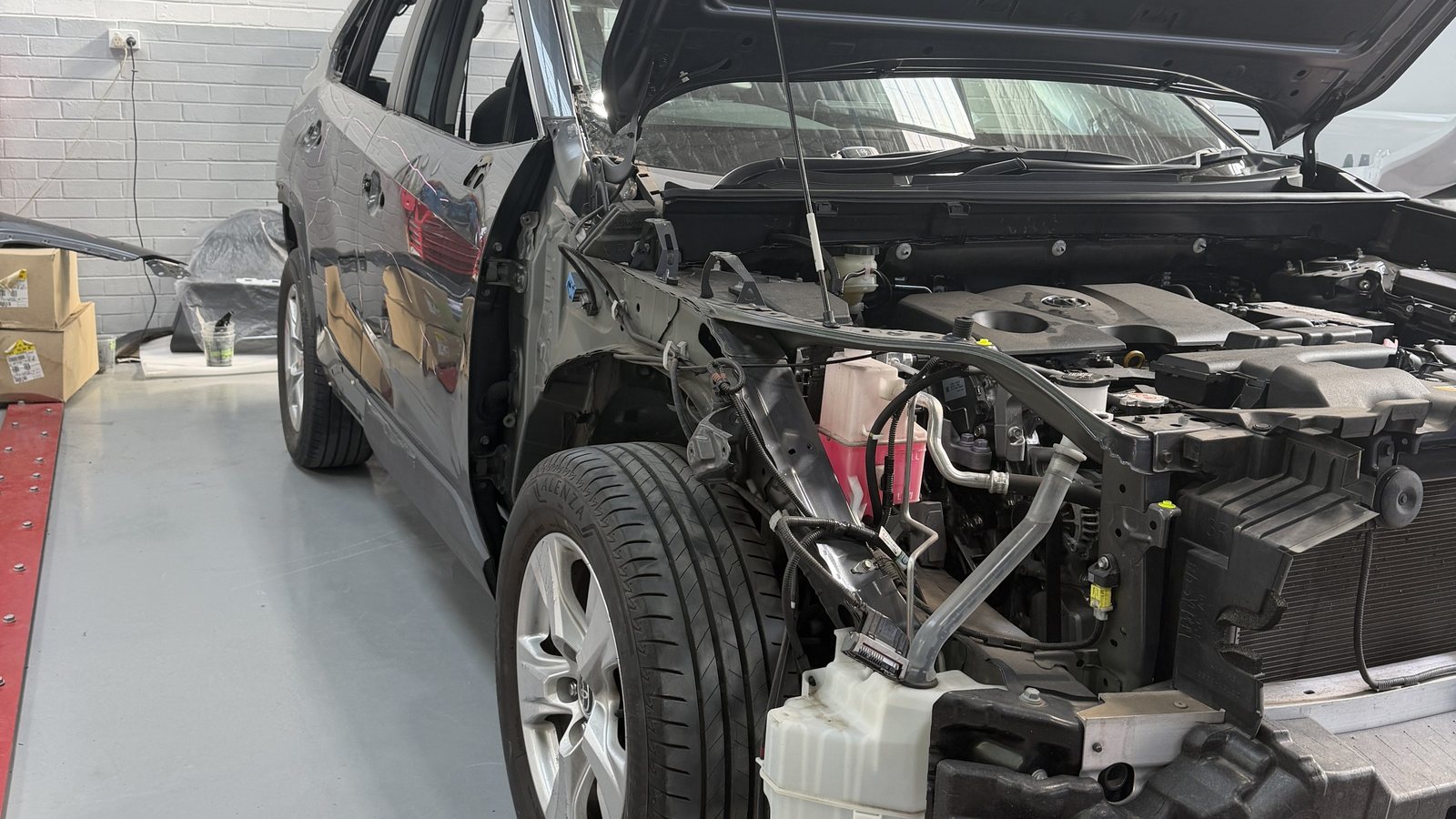 A car in for assessment at the Fineline workshop, bonnet up and front removed