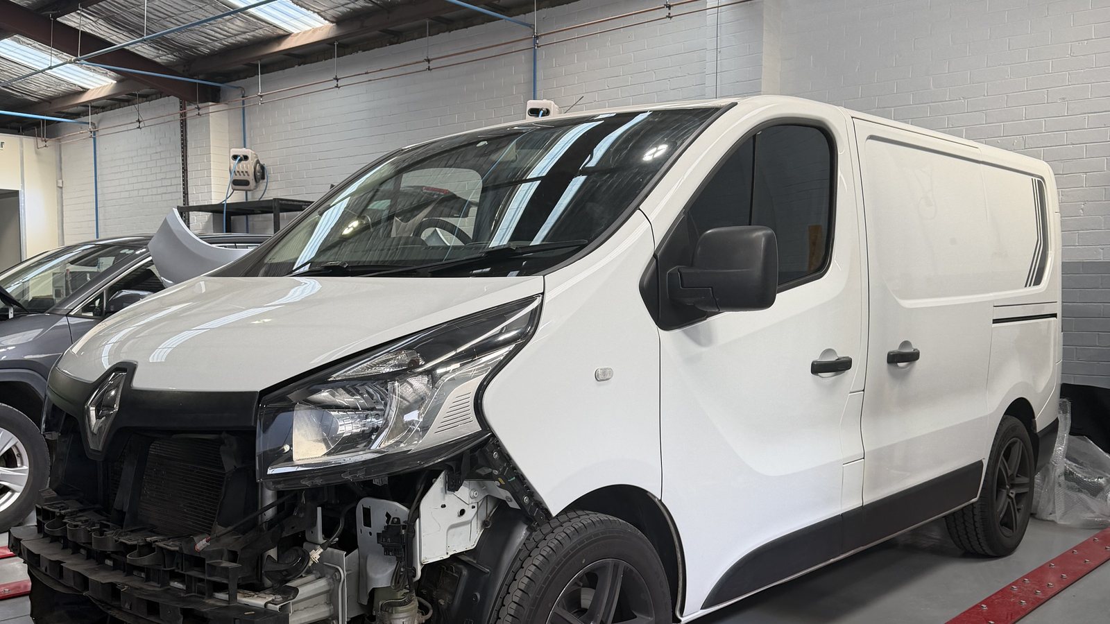 A van with its front stripped for accident repair on the Fineline workshop floor